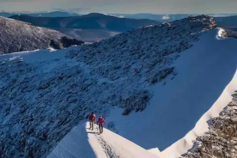 Två vandrare på en snöig bergskam, en dröm om att bestiga Kebnekaise blir verklighet.