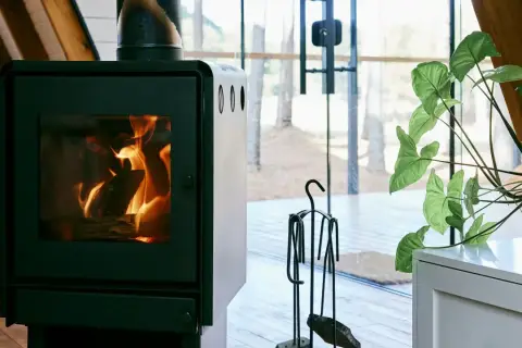 En modern pelletskamin utan skorsten ger värme och mys i ett hem med stora fönster.